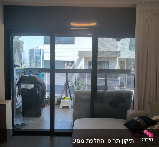 ויטרינת הזזה מאלומיניום עם תריס גלילה ורשת בסלון